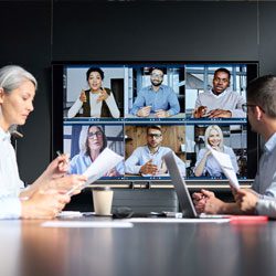 Global corporation online videoconference in meeting room with diverse people sitting in modern office and multicultural multiethnic colleagues on big screen monitor. 